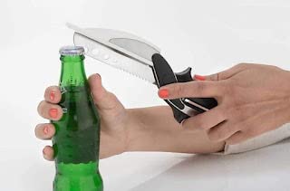 Hand using multi functional kitchen scissors with serrated blade and bottle opener to remove a green bottle cap