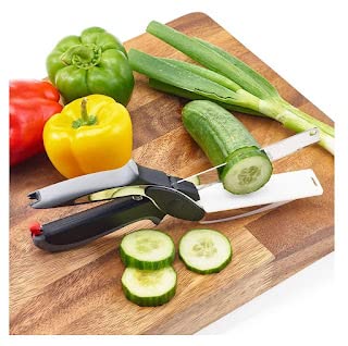 Black multi functional kitchen scissors slicing cucumber on wooden cutting board with bell peppers and green onions