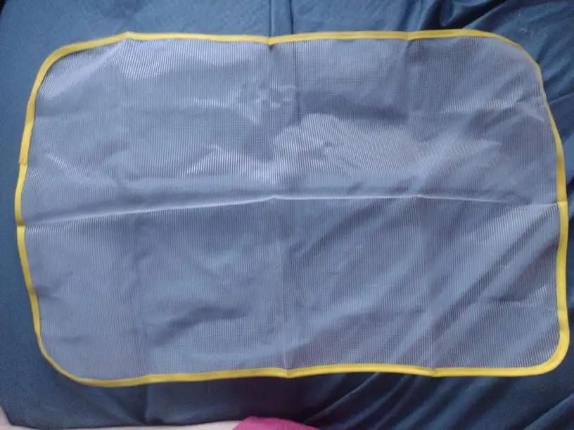 Durable iron safety mesh pad with yellow edges, perfect for protection during ironing tasks