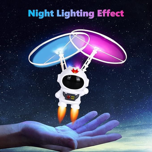 Kids astronaut flying toy with night lighting effect soaring above a hand in dark space
