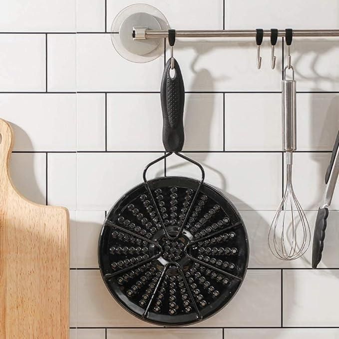 Black gas and electric stove diffuser hanging on a kitchen wall with utensils